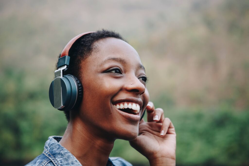 A happy woman wearing headphones joyfully listening to something