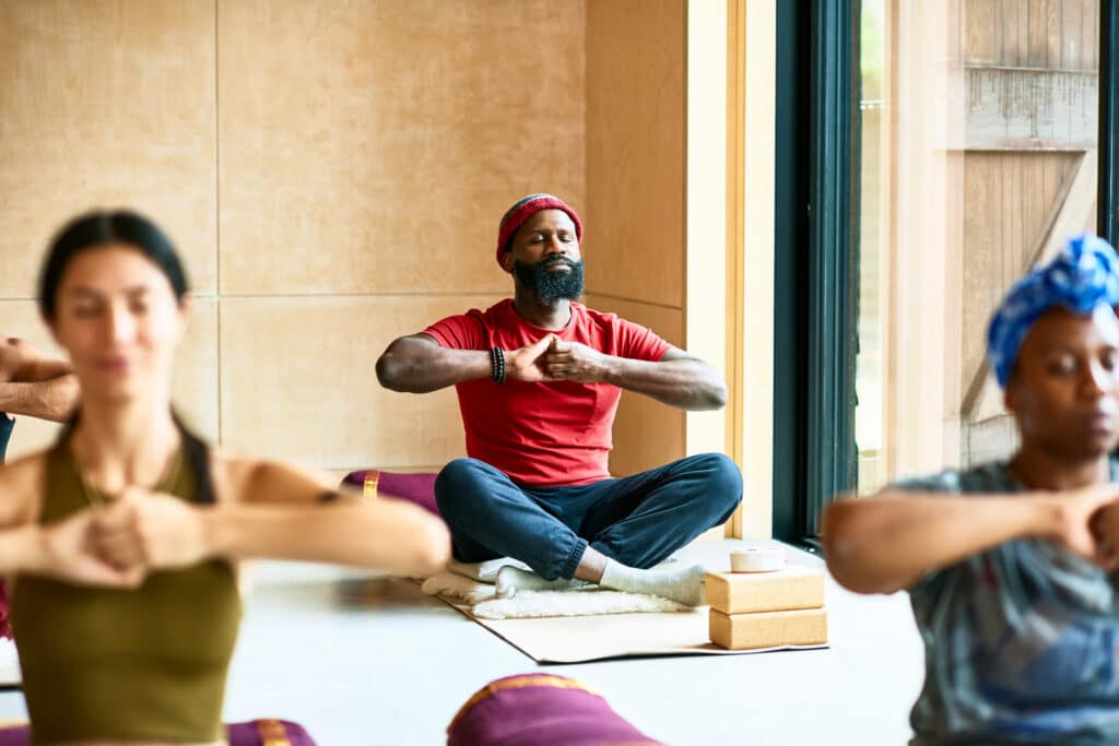 A serene yoga session with a diverse group of people stretching and meditating in a peaceful room